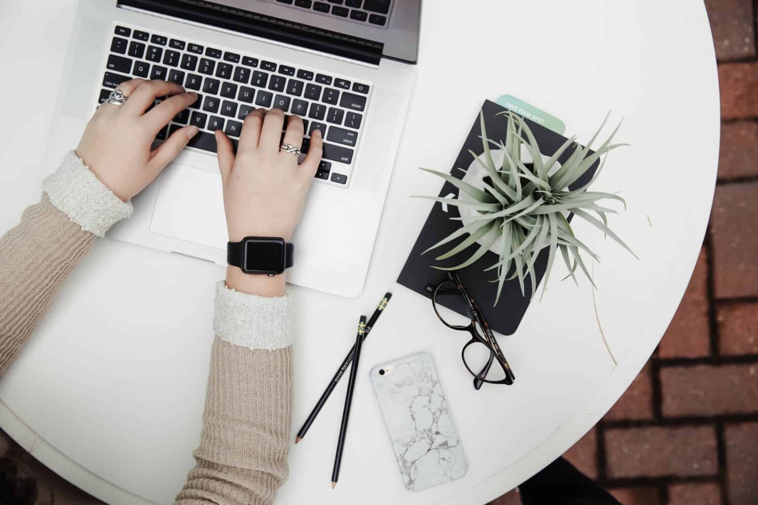 Person typing on laptop at tidy white desk