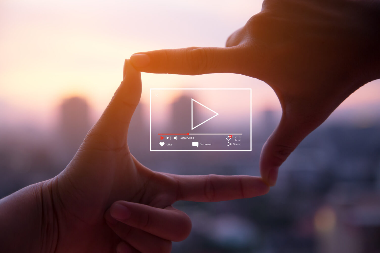 Hands framing sunset city with video player overlay