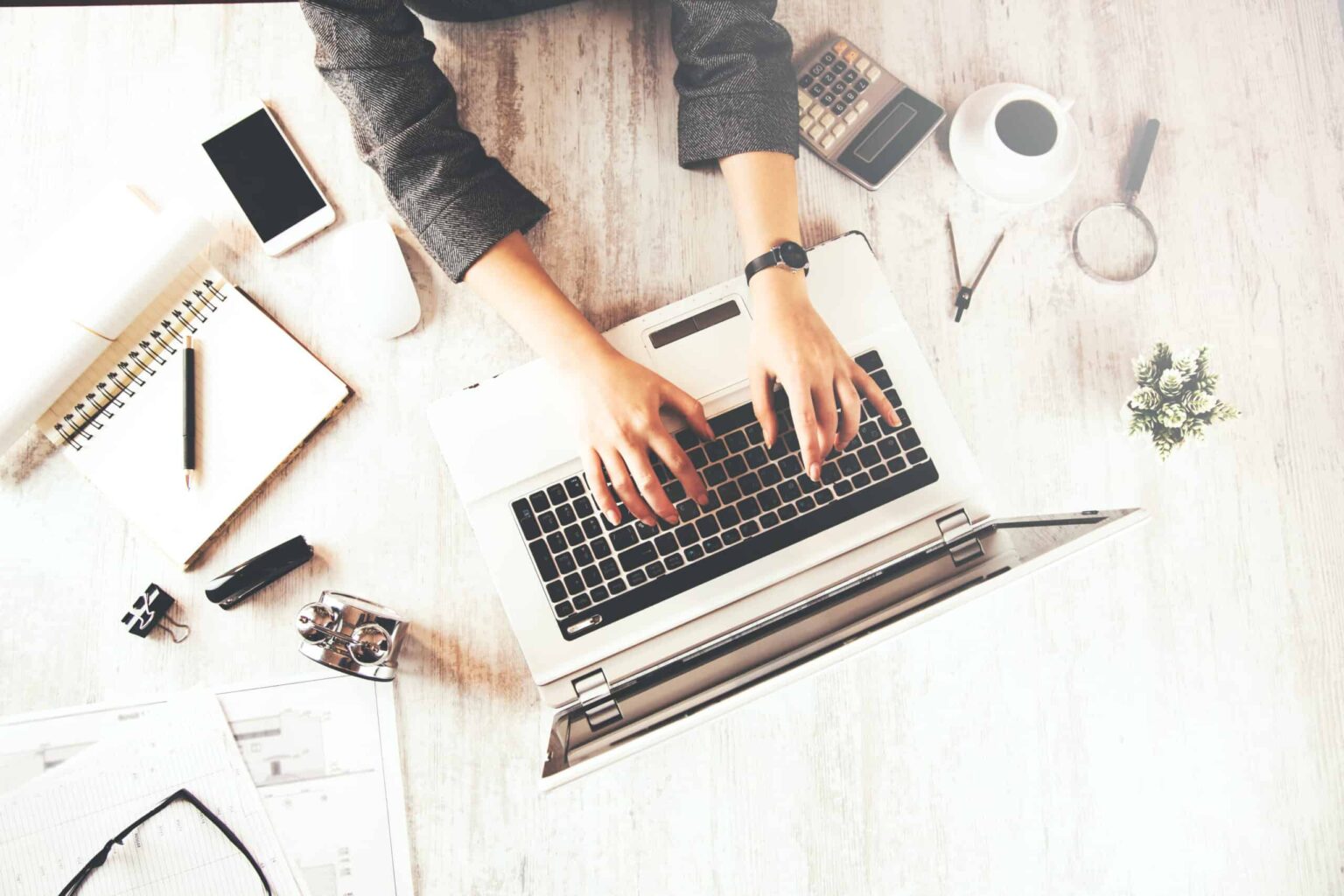Person typing on laptop at organised desk
