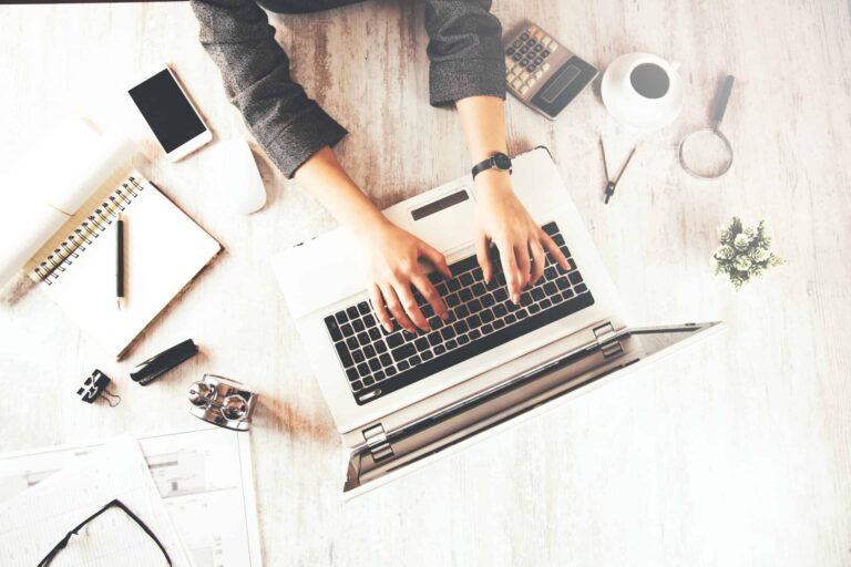 Person typing on laptop at organised desk