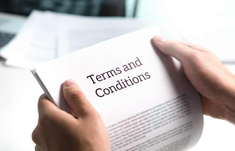 Hands holding document titled Terms and Conditions