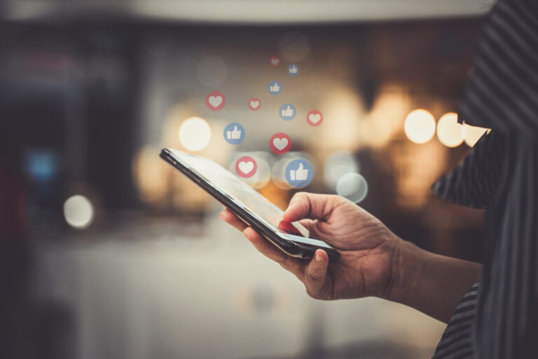 Person using smartphone with social media icons