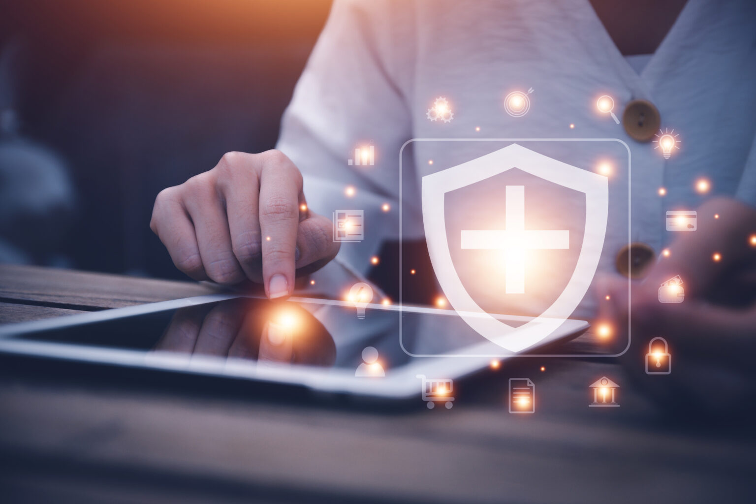 Person using tablet with digital healthcare security shield