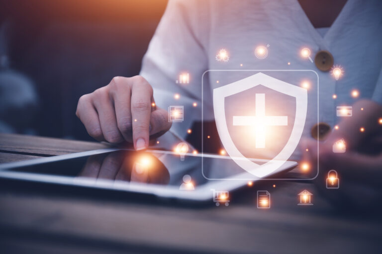 Person using tablet with digital healthcare security shield