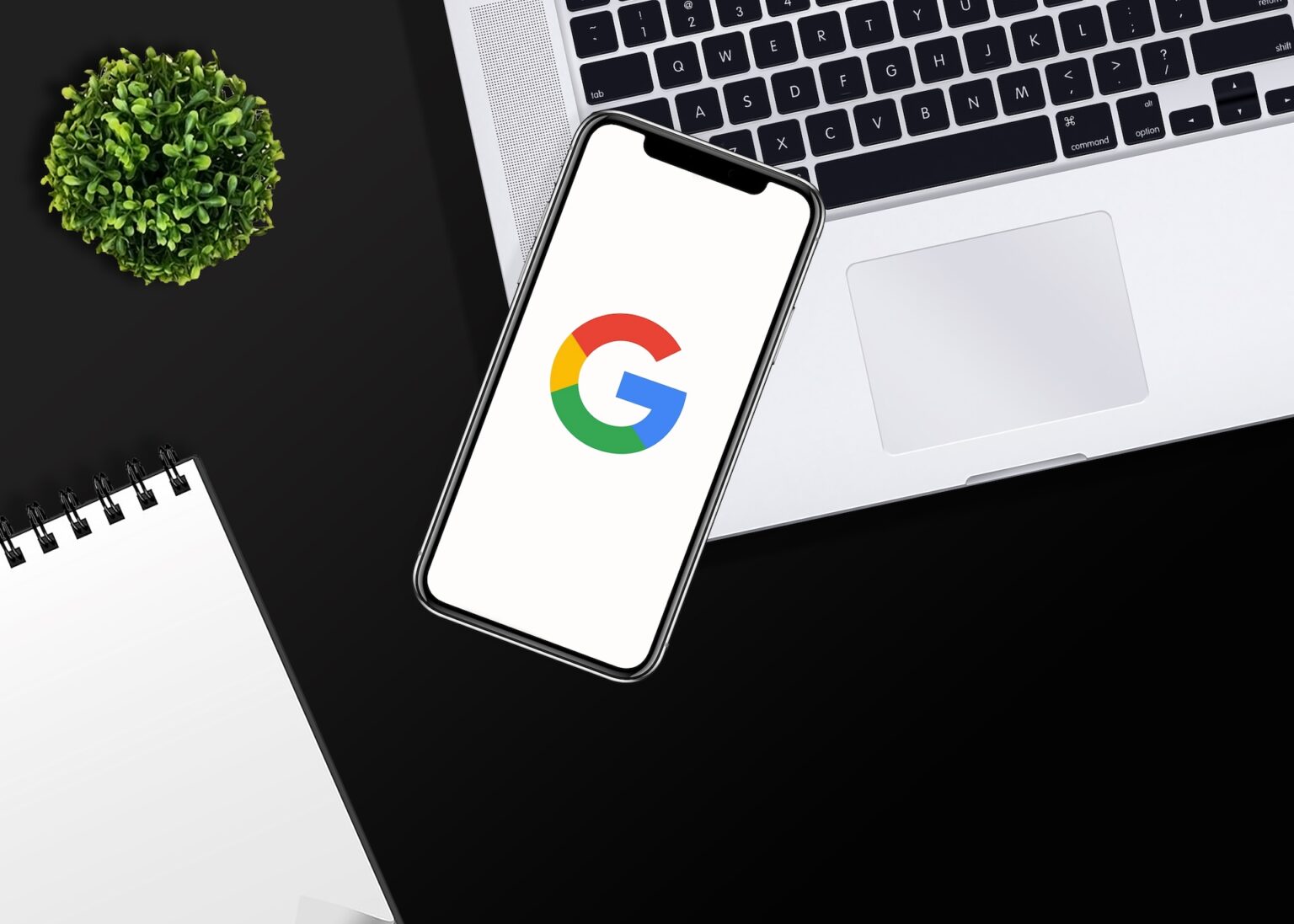 Smartphone displaying Google logo on laptop keyboard