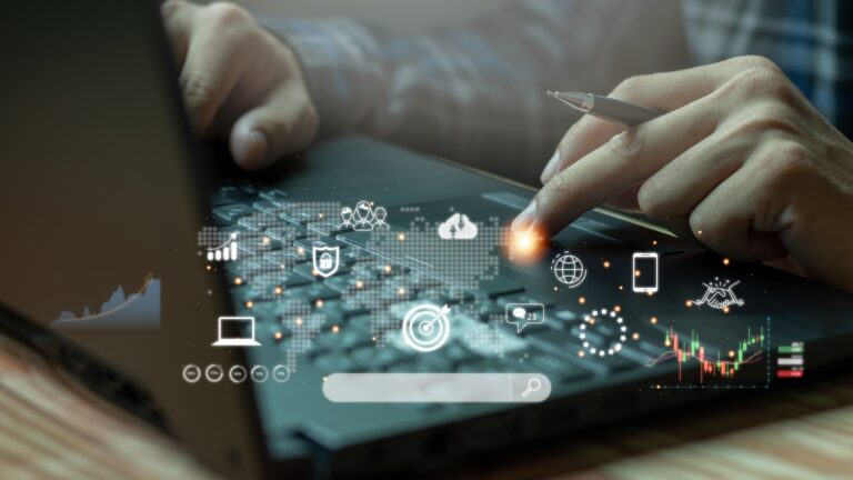 Person using laptop with digital business icons overlay