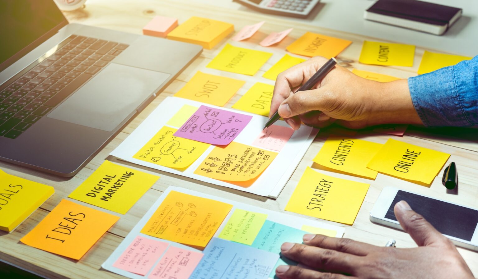 Person planning digital marketing strategy with sticky notes