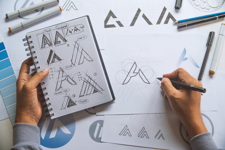 Designer sketching geometric logo concepts at desk