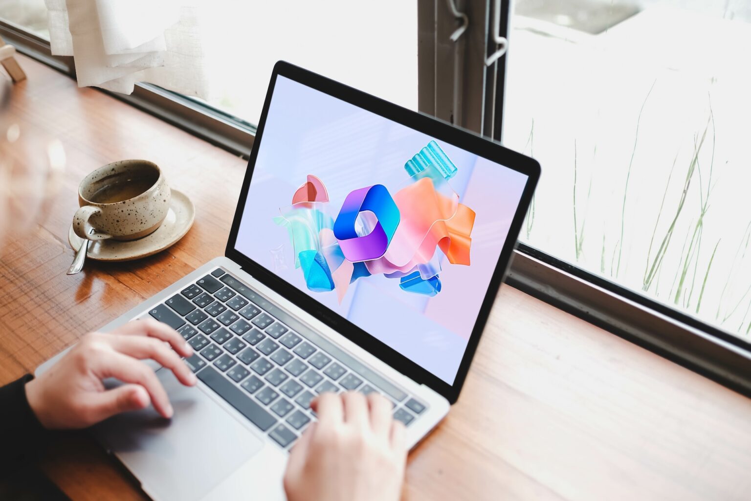 Person using laptop with Microsoft 365 on screen