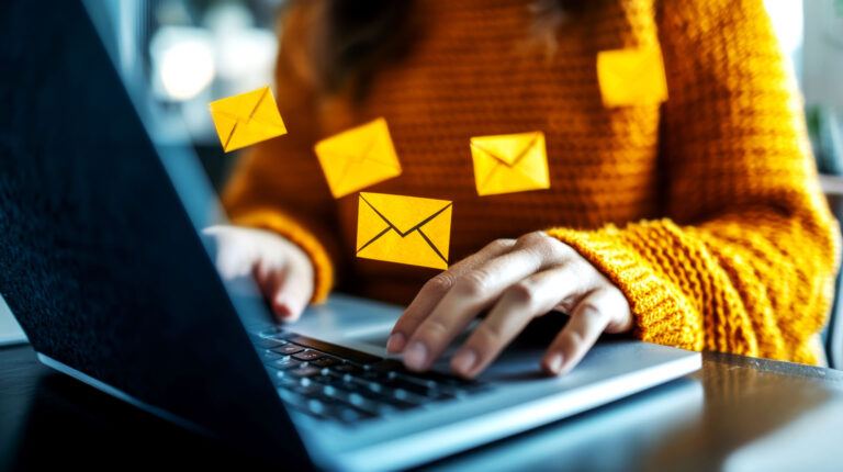 Person typing on laptop with floating email icons
