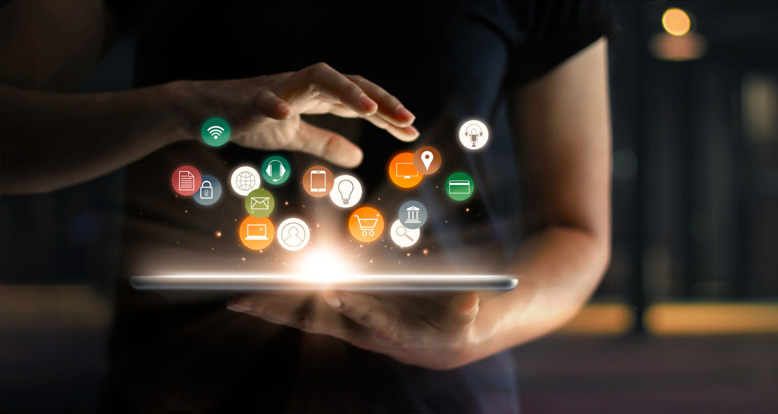 Hands using tablet with glowing digital app icons