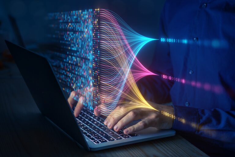 Person typing on laptop with flowing digital data