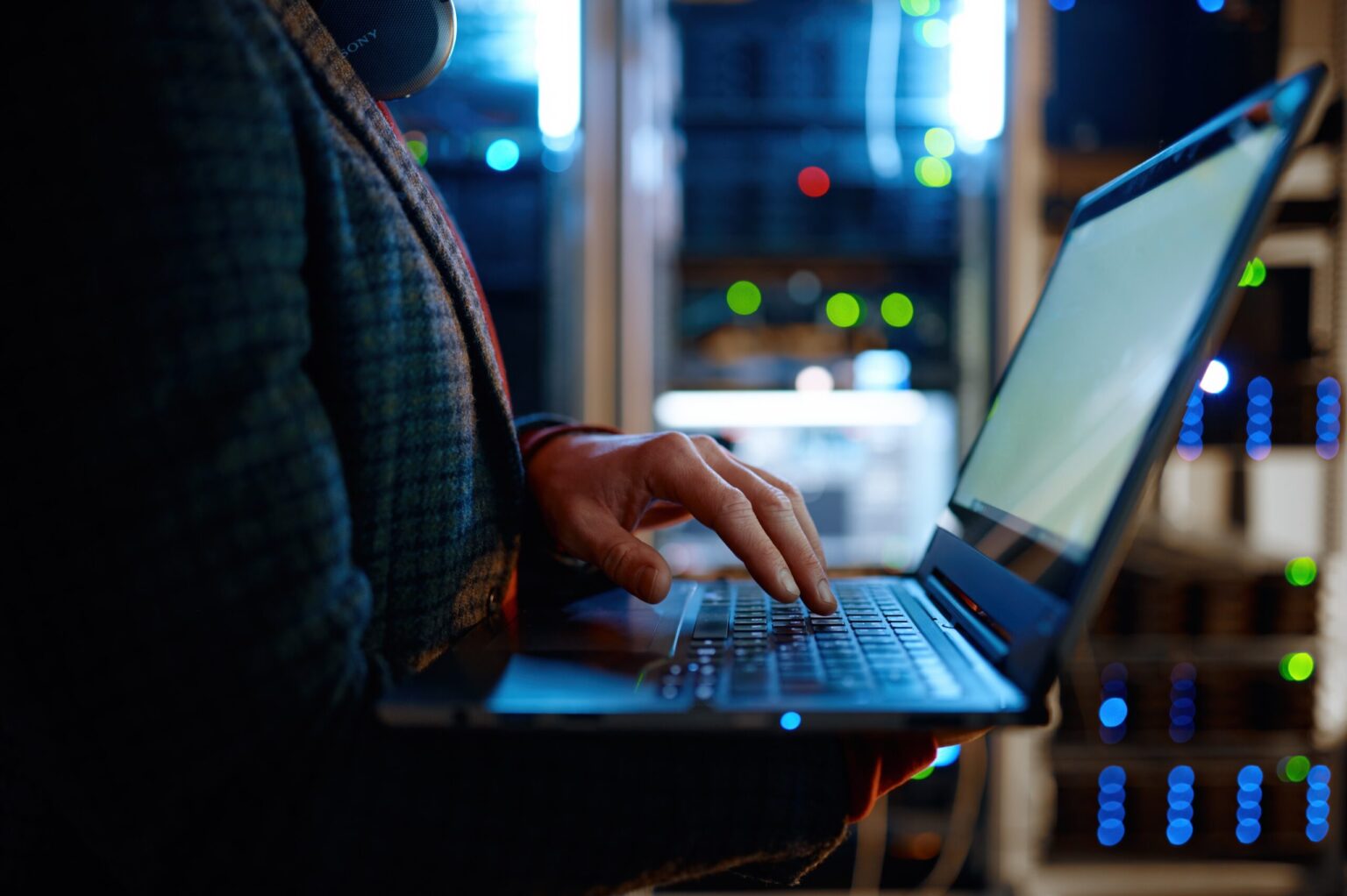 Person typing on laptop in data centre